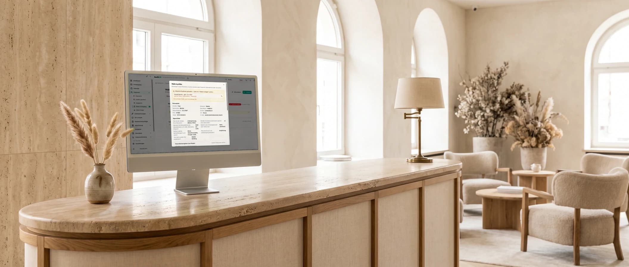 iMac am Empfangstresen zeigt die Prüfung einer Aufnahme mit Stammdaten, eigenen Feldern und dem Bereich Gesundheitsangaben aus dem Bogen