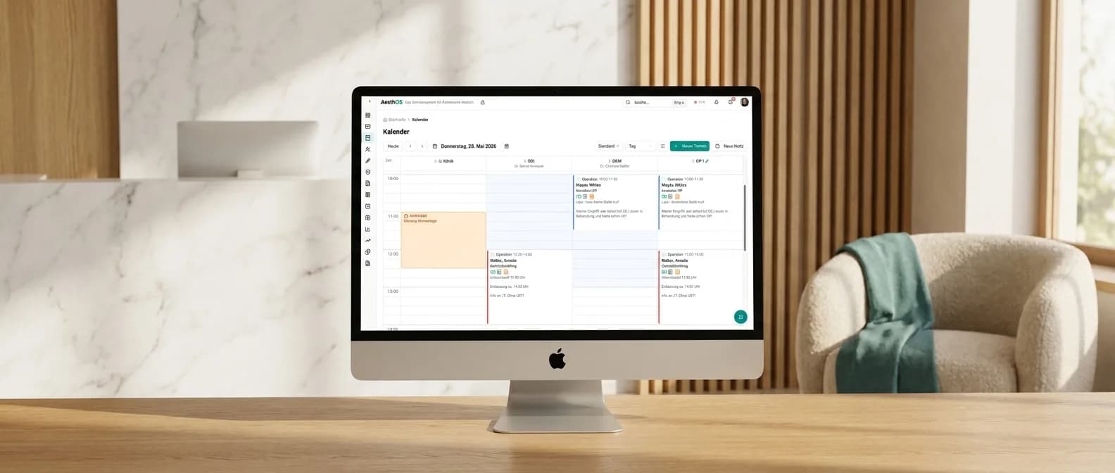 27-Zoll-iMac frontal auf Marmor-Empfang zeigt die AesthOS-Kalender-Ansicht mit frei konfigurierbaren Spalten — hier exemplarisch Klinik, zwei Behandler und ein OP-Saal nebeneinander
