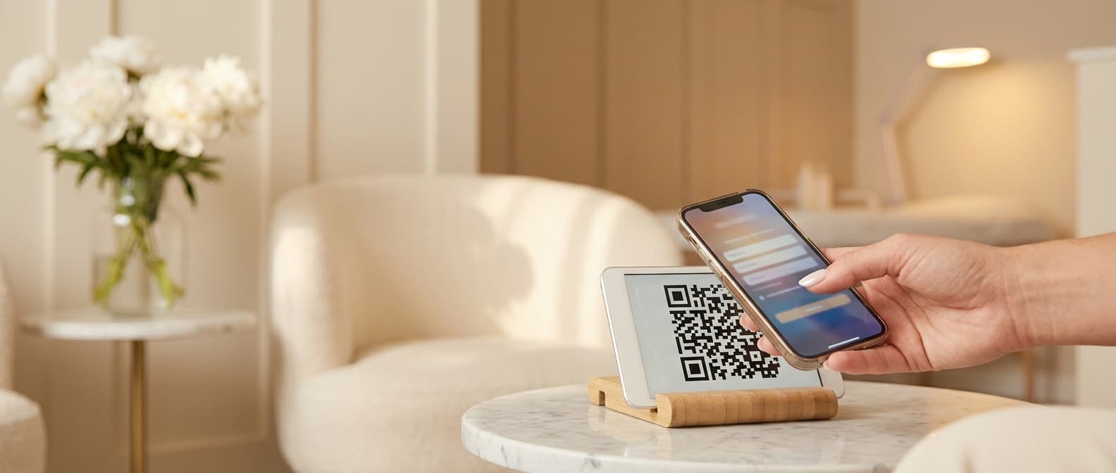 Patientin scannt im Wartebereich einer ästhetischen Klinik einen QR-Code mit ihrem Smartphone — Aufnahmeformular öffnet sich
